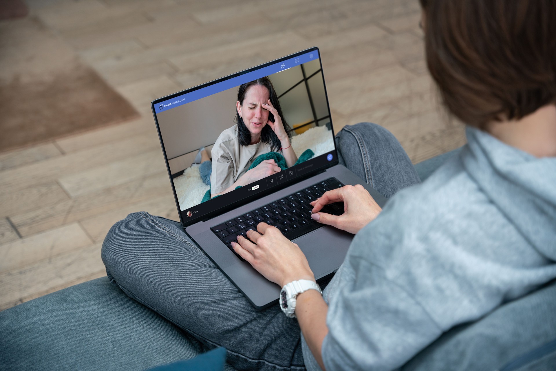 Young woman using laptop for video call with girlfriend. Crying woman on the laptop screen, psychotherapy video call